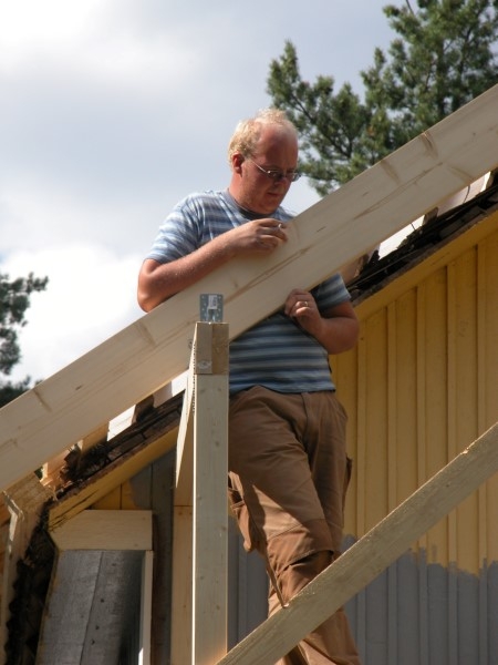 Mies tarkastelee talon puukehikkoa.